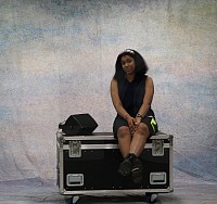 Leiona sat on a flight case with a speaker to her right on the flight case